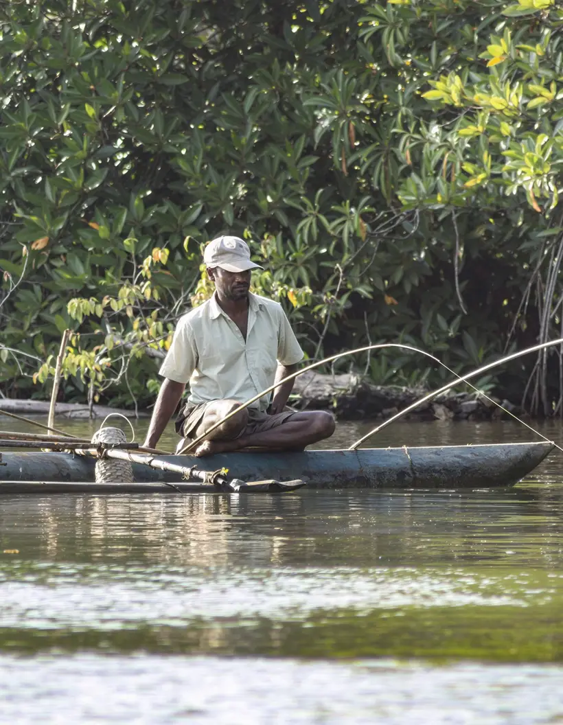 Traditional Fishing on Madu River Local fisherman fishing from a traditional wooden boat on the Madu River