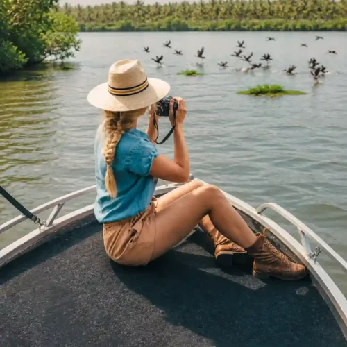 Woman using binoculars to watch birds during a Madu River safari