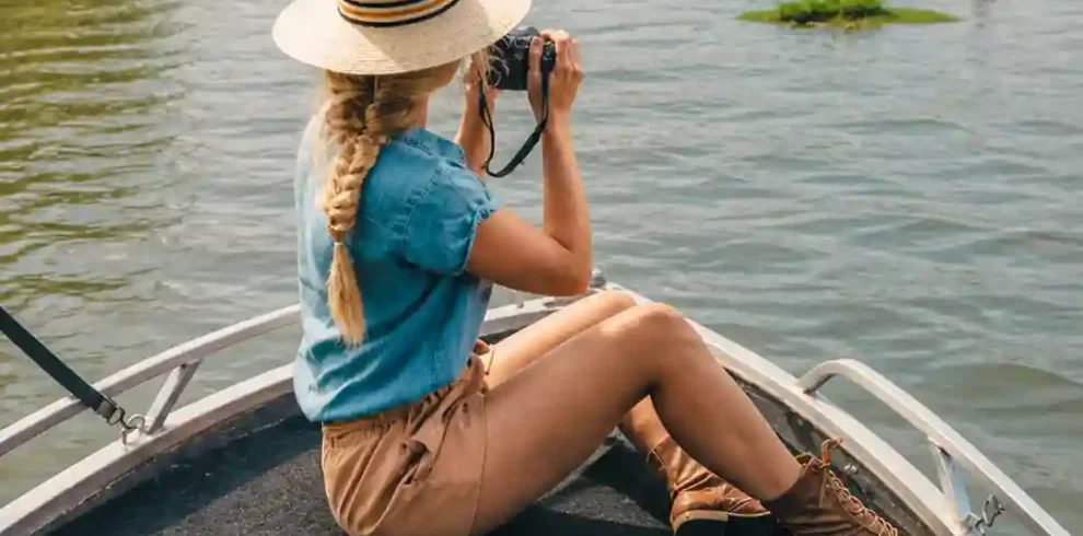 Woman using binoculars to watch birds during a Madu River safari