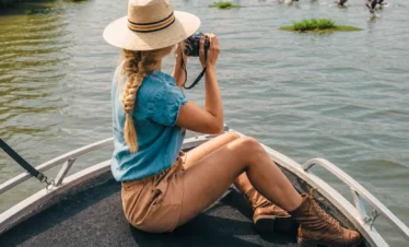 Woman using binoculars to watch birds during a Madu River safari