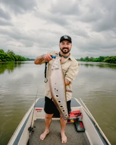 Happy fisherman showing a big fish caught on the Madu River