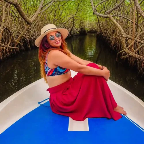 Sri Lankan woman traveling through Madu River mangrove tunnels by boat