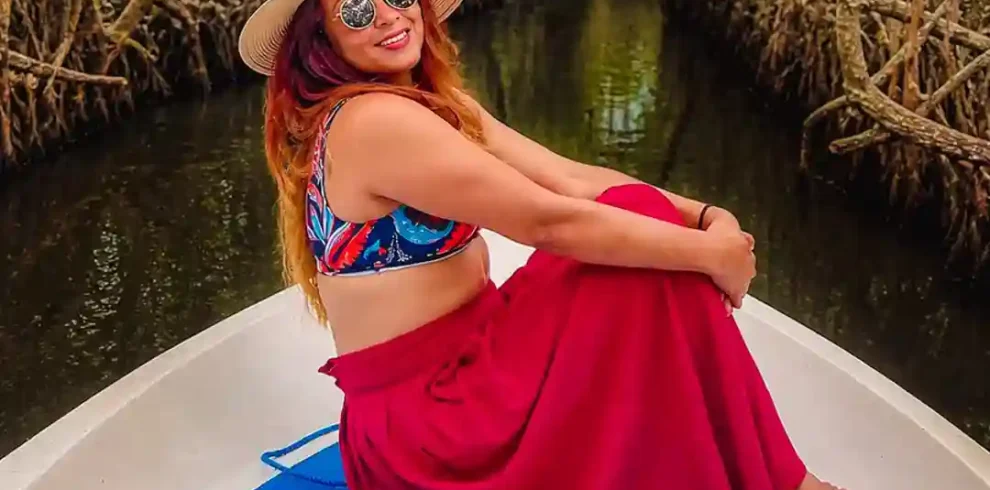 Sri Lankan woman traveling through Madu River mangrove tunnels by boat