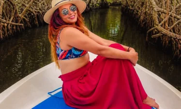 Sri Lankan woman traveling through Madu River mangrove tunnels by boat