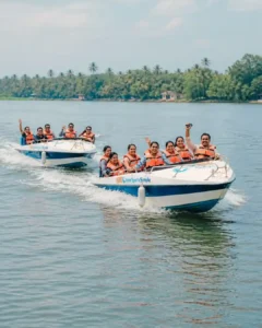 Two safari boats with happy travelers cruising along the Madu River