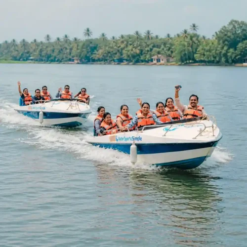 Two safari boats with happy travelers cruising along the Madu River