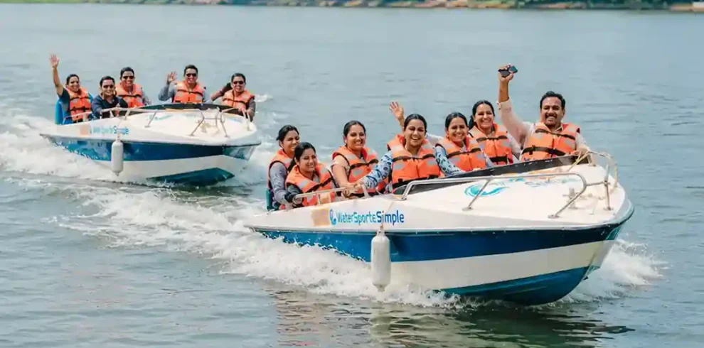 Two safari boats with happy travelers cruising along the Madu River
