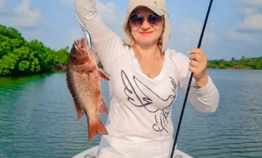 Tourist displaying a large fish caught during a freshwater fishing experience in Sri Lanka