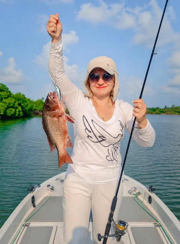 Tourist displaying a large fish caught during a freshwater fishing experience in Sri Lanka