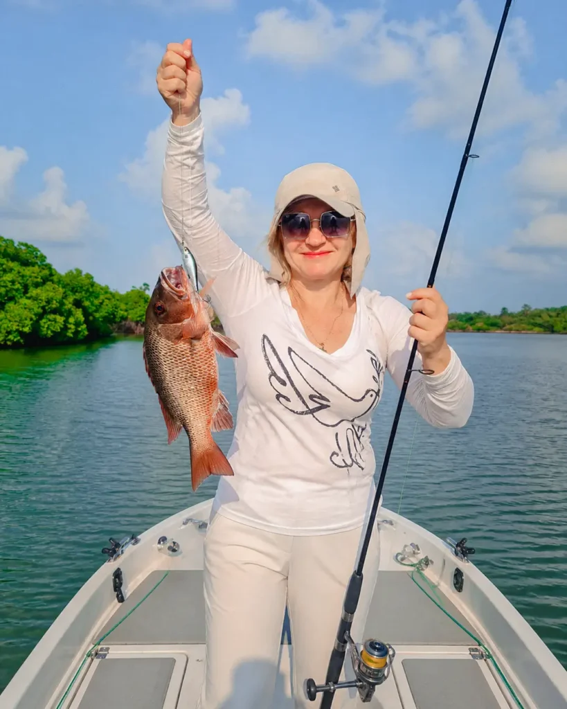 Tourist displaying a large fish caught during a freshwater fishing experience in Sri Lanka
