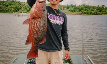 Angler posing with a large fish caught during a Madu River boat safari