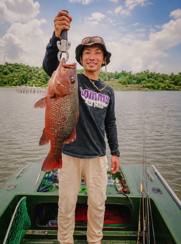 Angler posing with a large fish caught during a Madu River boat safari