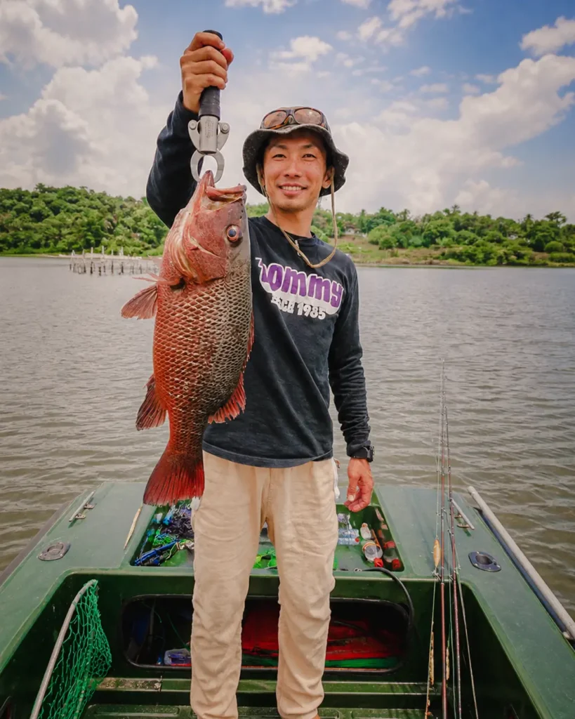 Angler posing with a large fish caught during a Madu River boat safari