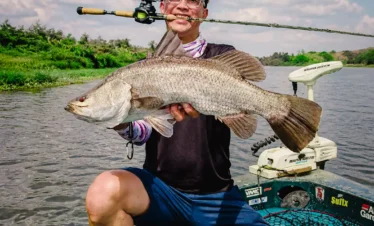 Angler showing a freshly caught fish during a traditional fishing trip on the Madu River in Sri Lanka