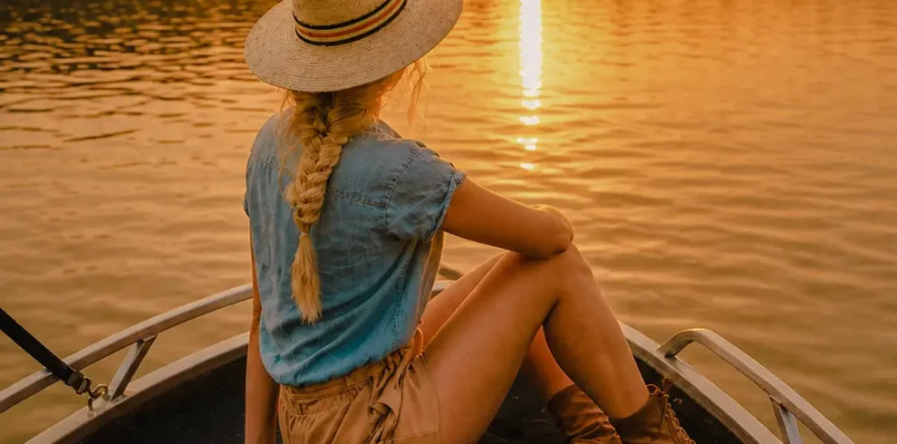 Woman enjoying the sunset during a peaceful Madu River boat safari