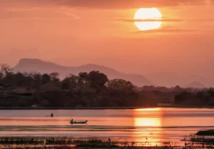 Jaliya Boat Safari guests enjoying a peaceful sunset cruise on the Madu River, Sri Lanka, with golden light over the water